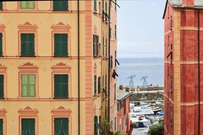 Un bâtiment situé sur la côte, doté de nombreuses fenêtres et de balcons, qui offre une vue sur un port de plaisance rempli de bateaux.