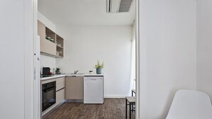 A compact kitchen with a dishwasher, a coffee machine, and a small plant on the counter. - Deluxe Apartment - Grey by Wonderful Italy (Genoa)