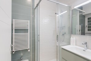 A modern bathroom with a glass shower enclosure, a white sink, and a towel rack. - Studio Glicine by Wonderful Italy (Turin)