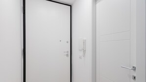 A white door with a black frame, a white wall, and a white door handle. - Studio Glicine by Wonderful Italy (Turin)