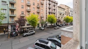 A multi-story residential building with balconies, parked cars, and a pedestrian walkway. - Studio Glicine by Wonderful Italy (Turin)