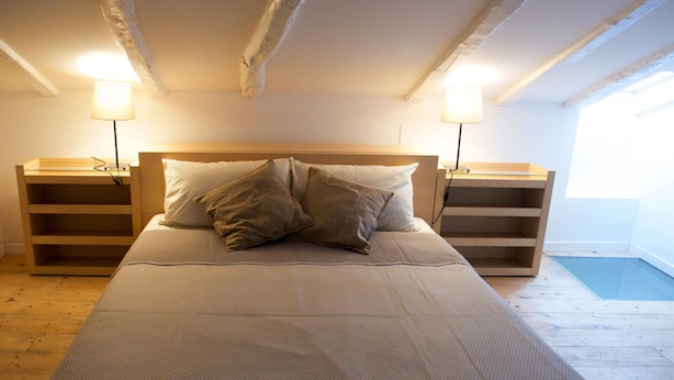 Una camera da letto con un letto, due comodini e una finestra.