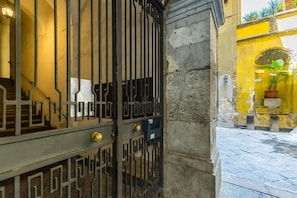 Secure entrance to a beautifully maintained property with a decorative gate and lush greenery.