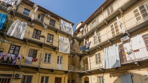 Um edifício de vários andares com varandas, algumas com roupas penduradas.