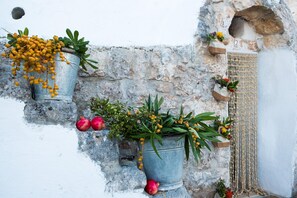 Un muro de piedra rústico con macetas y flores.