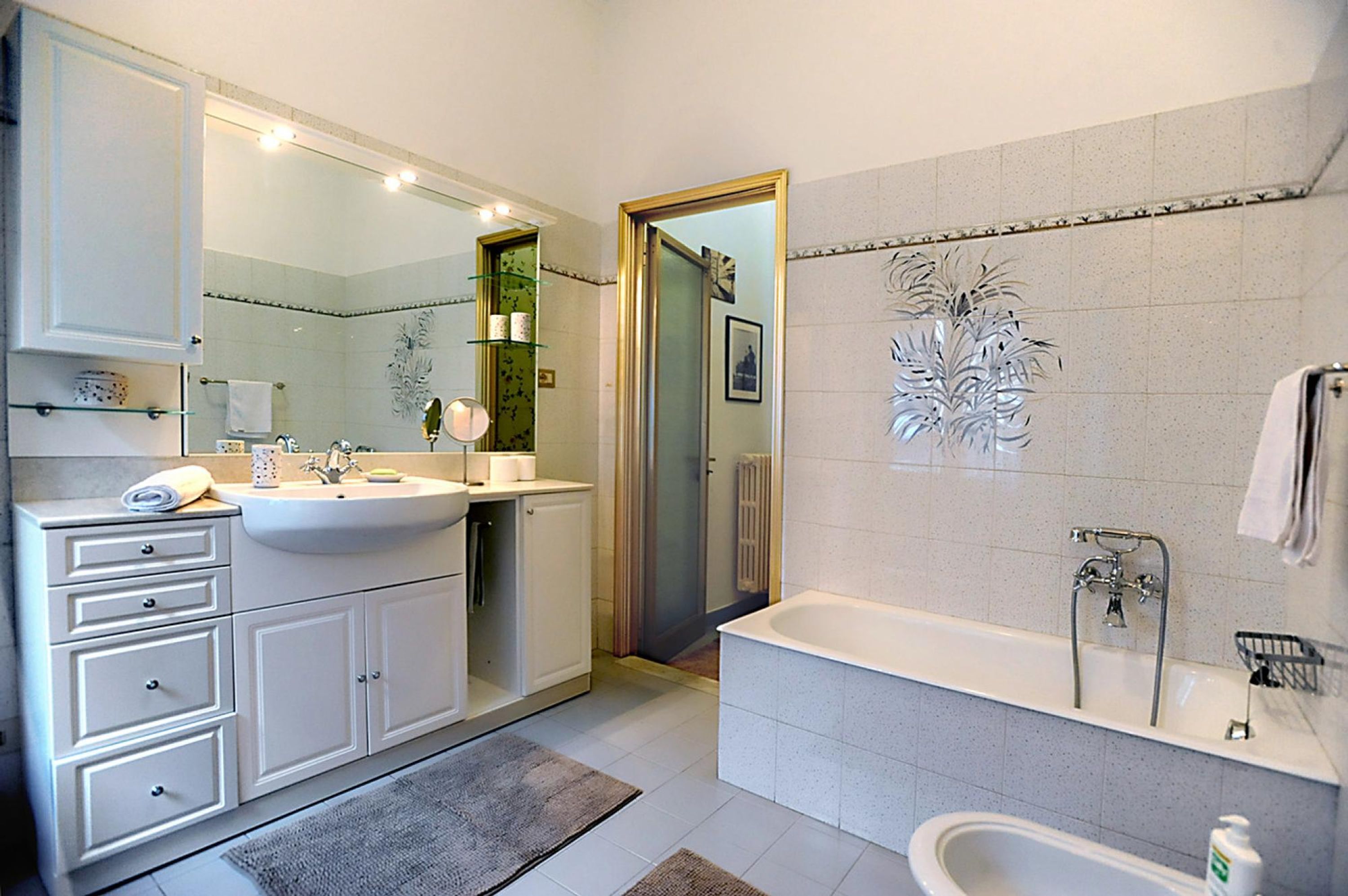 A modern bathroom with a large sink, a bathtub, and a shower area.