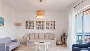 A living room with a sofa, a coffee table, a lamp, and a painting on the wall.