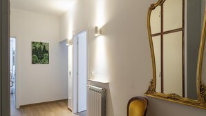 A hallway with a radiator, a chair, and a large mirror on the wall.