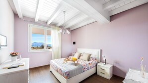 A bedroom with a bed, bedside tables, a desk, and a window with a view of mountains. - Warda C11 con Piscina by Wonderful Italy (Desenzano del Garda)