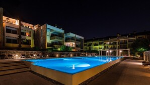 A rectangular swimming pool with a stone border, surrounded by a paved area with steps leading up to a stone wall. - Warda C11 con Piscina by Wonderful Italy (Desenzano del Garda)