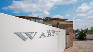 A building with a sign that reads "Warda Residences". - Warda C11 con Piscina by Wonderful Italy (Desenzano del Garda)