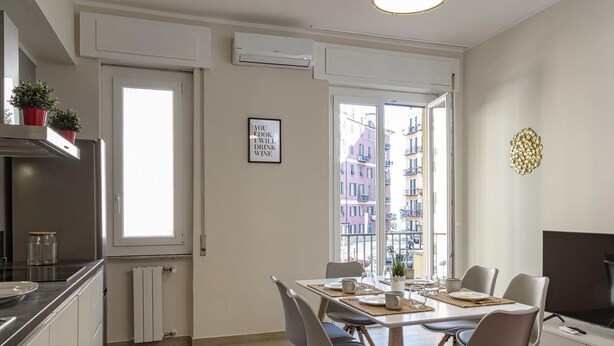 Ett modernt kök med matplats, ett stort fönster med utsikt över staden och en platt-TV.