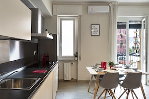 A modern kitchen with a built-in stove, a window, and a dining area with a table set for two.