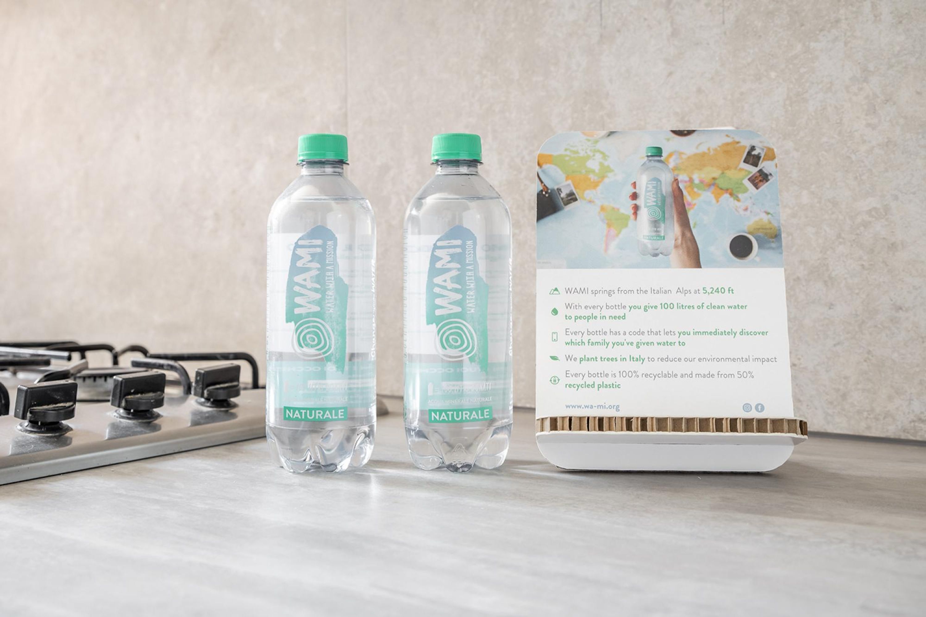 Dos botellas de agua WAMI y un folleto sobre una encimera de cocina.