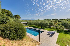 A rectangular swimming pool with a clear blue water surface, surrounded by a wooden deck. There are lounge chairs and a small gazebo in the background. - Castelletto 1 - Piscina Jacuzzi by Wonderful Italy (Polpenazze del Garda)