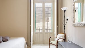 A hotel room with a bed, a chair, a desk, a lamp, and a mirror. - Cavour Apartment Near the Cathedral by Wonderful Italy (Noto)