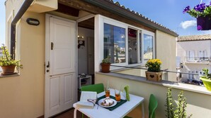 A balcony with a table, chairs, and potted plants. - Salomone Apartment 13 With Terrace by Wonderful Italy (Syracuse)
