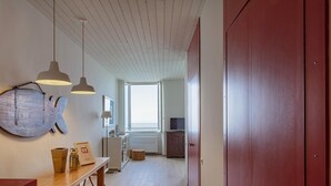 A hallway with a wooden floor, a large wooden sign on the wall, and a red door. - Il Mare di Camogli da un Obl by Wonderful Italy (Camogli)