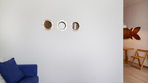 A room with a blue sofa, a wooden chair, and a wall-mounted mirror. - Il Mare di Camogli da un Obl by Wonderful Italy (Camogli)