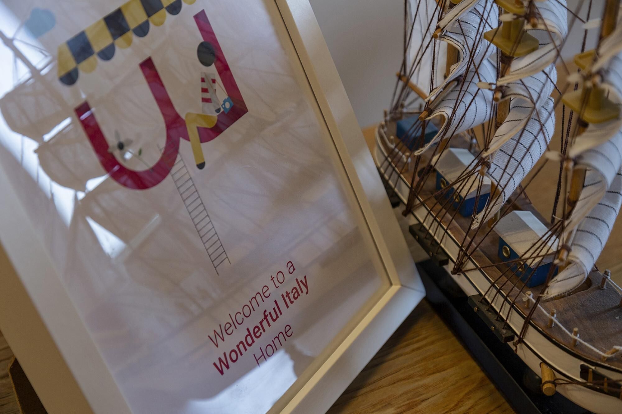 A model ship and a framed welcome sign with a ladder.
