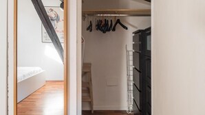 A hallway with a wooden floor leading to a bedroom with a bed and a staircase. - La Mansarda di Via Zamboni by Wonderful Italy (Bologna)