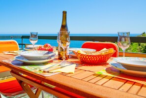 A table set for dining with a view of the sea, a bottle of wine, and a basket of bread. - Le Orchidee 14 con Vista Mare by Wonderful Italy (Sanremo)