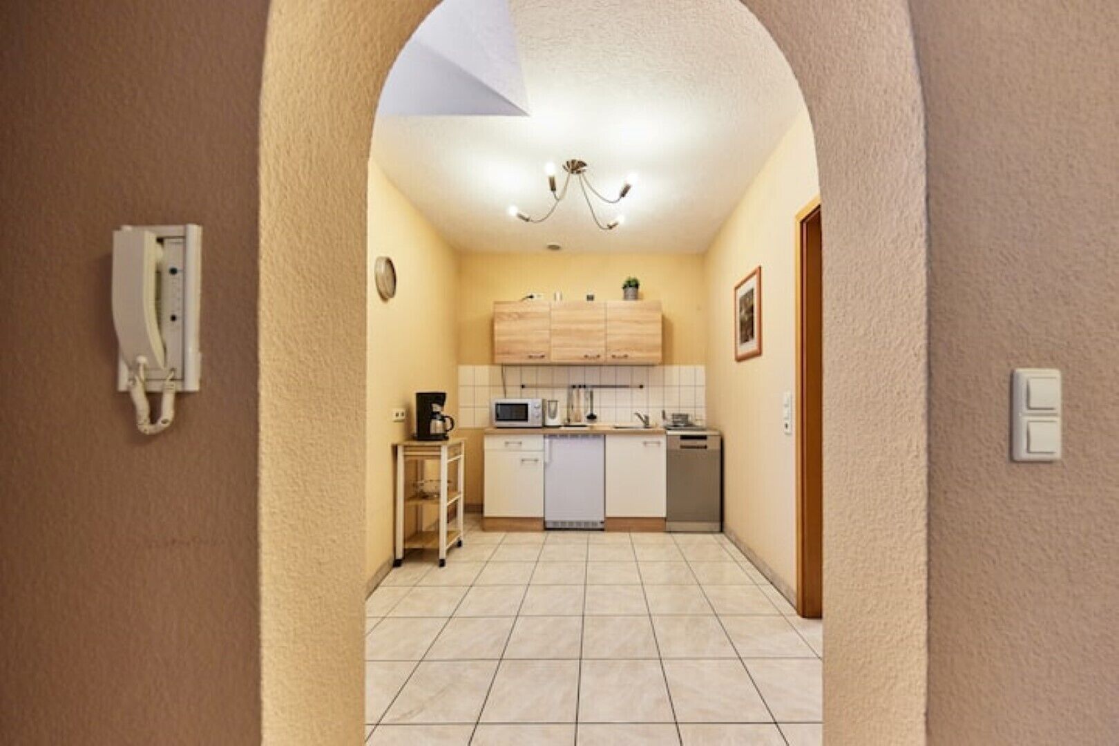 A compact kitchen with a microwave, coffee maker, and a small table.