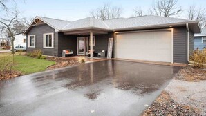 A two-story house with a garage, a covered patio, and a driveway.