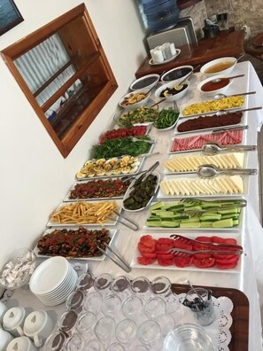 A buffet table with various food items and utensils. - Limon Otel  (Foça)