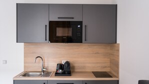 Une cuisine moderne équipée d’un four à micro-ondes encastré, d’une machine à café et d’un évier.