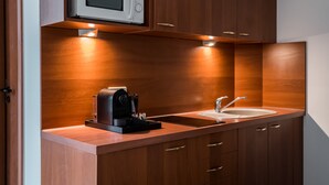 Une cuisine moderne équipée d’un four à micro-ondes encastré, d’une machine à café et d’un évier.