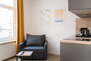 Relax in this cozy space with a comfortable sofa, compact kitchenette, and large window.