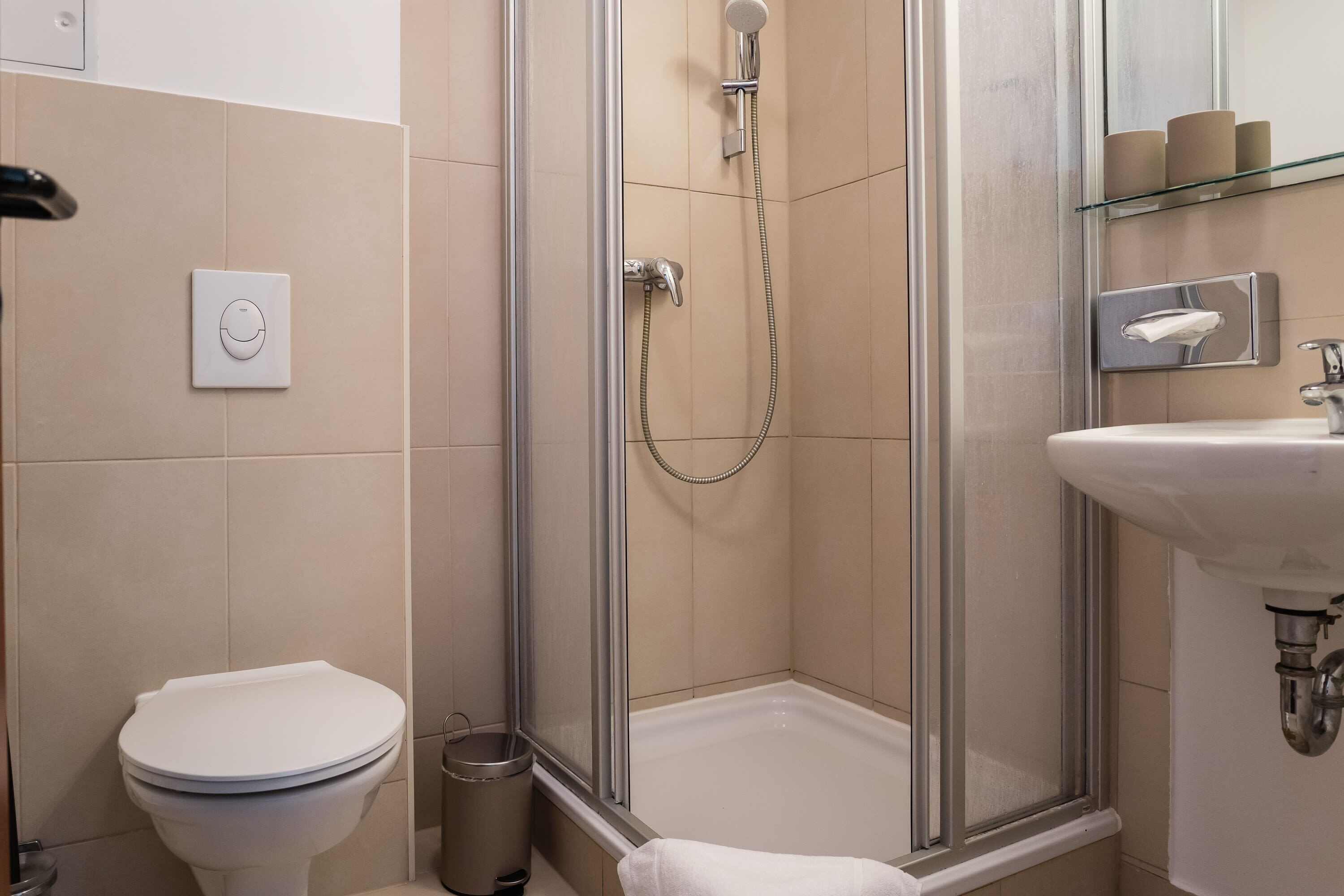 A modern bathroom with a toilet, shower, and sink.