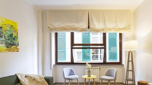 A room with a sofa, two chairs, a small table, a lamp, and a TV. - XXV Aprile - Basilico by Wonderful Italy (Genoa)