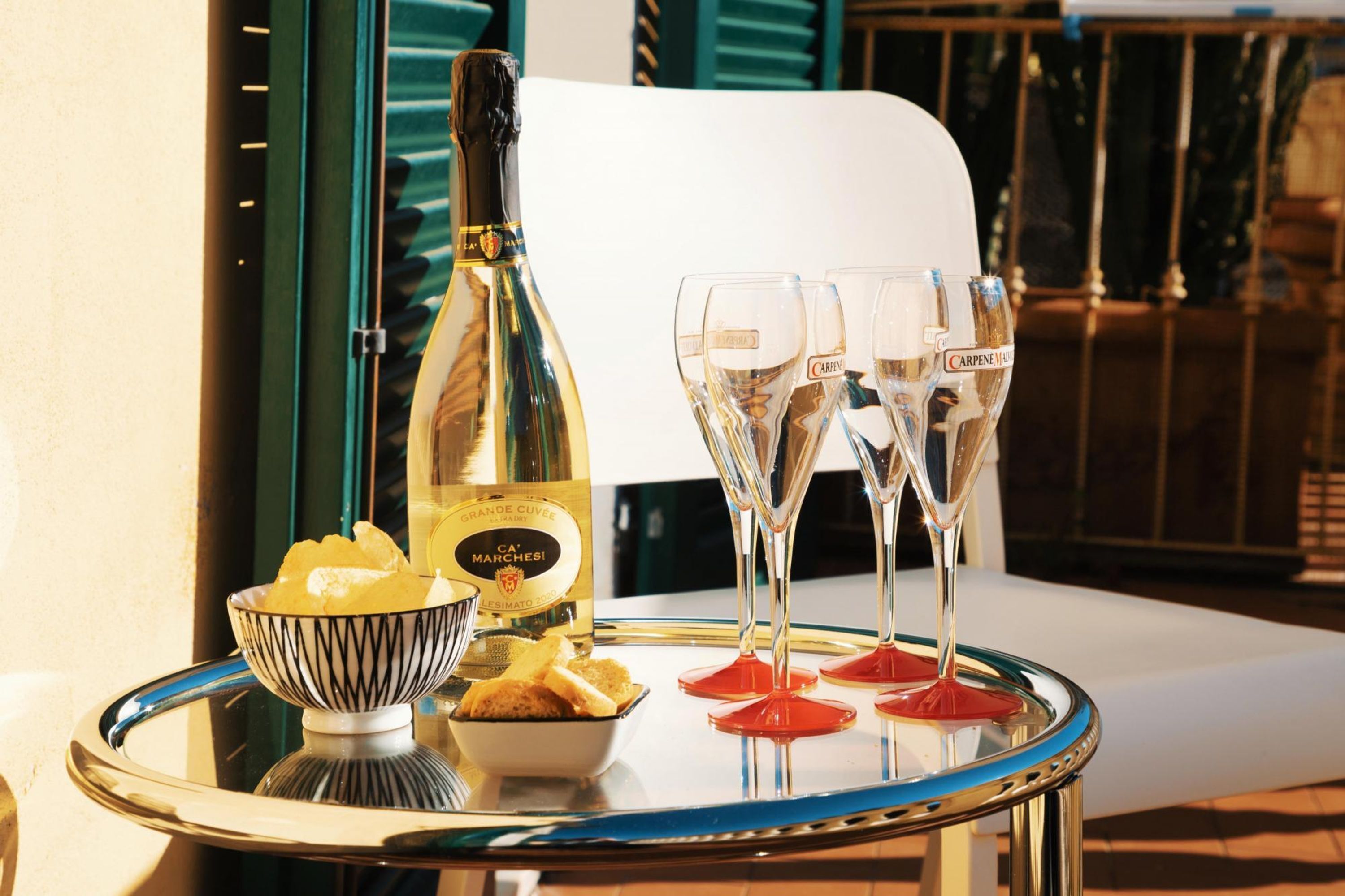 Une table avec une bouteille de champagne, deux verres et un bol de collations.