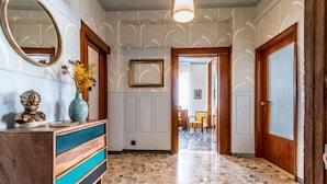 A hallway with patterned walls, a marble floor, and wooden doors. - Dimora Vintage San Tommaso by Wonderful Italy (Bologna)