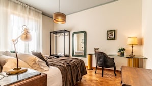 A hotel room with a bed, bedside table, desk, chair, and a mirror. - Dimora Vintage San Tommaso by Wonderful Italy (Bologna)