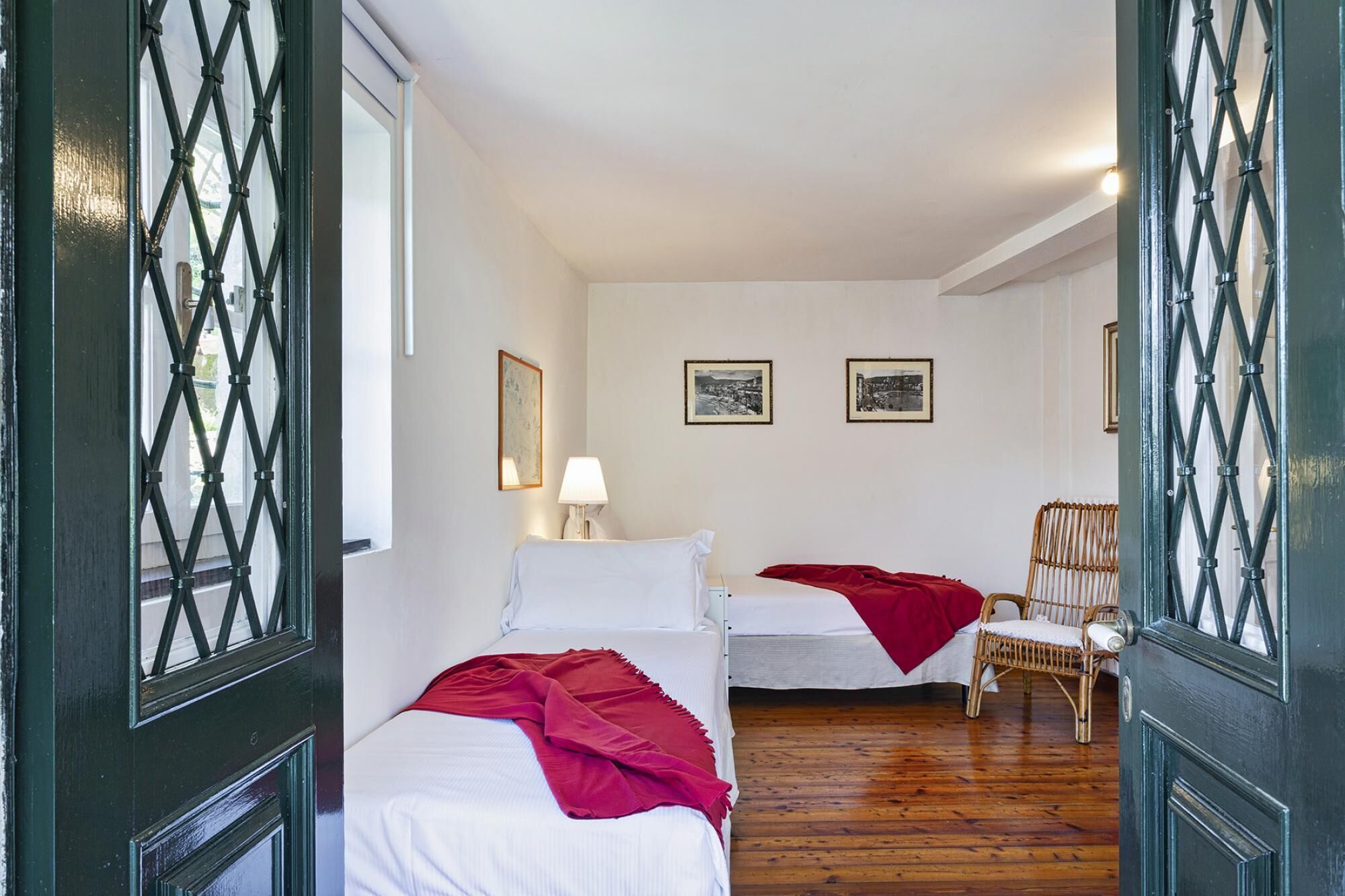 A room with two beds, a chair, and a lamp.