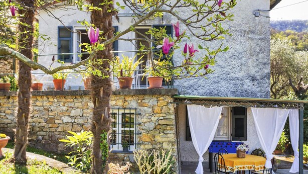 A stone building with a covered patio area, potted plants, and a table with a yellow tablecloth. - Villa Rica by Wonderful Italy (Santa Margherita Ligure)