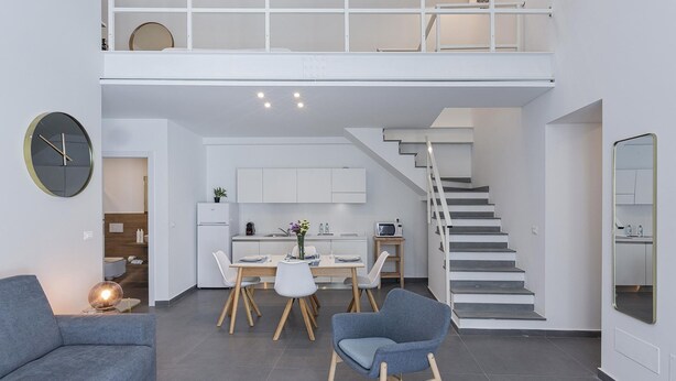 A modern interior with a dining area, kitchen, and staircase.