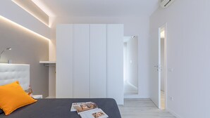Ein modernes Schlafzimmer mit einem Bett, einem Nachttisch, einer Zeitschrift und einem Kleiderschrank.