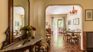 A spacious hallway with a marble console table, a large mirror, and a herringbone floor. - Un Giardino Segreto a Palermo by Wonderful Italy (Palermo)