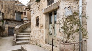 A stone building with a staircase leading to a door marked with the number 5. - Casa Petra by Wonderful Italy (Modica)