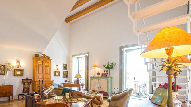 A cozy living room with a wooden cabinet, a sofa, a dining table, and a large lamp. - Charming Apartment by Wonderful Italy (Palermo)