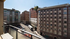 Un edificio alto con varios pisos, amplias ventanas y una calle visible abajo.