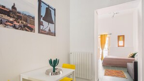 Une pièce comprenant une table à manger, des chaises, un radiateur, un canapé et un lit.