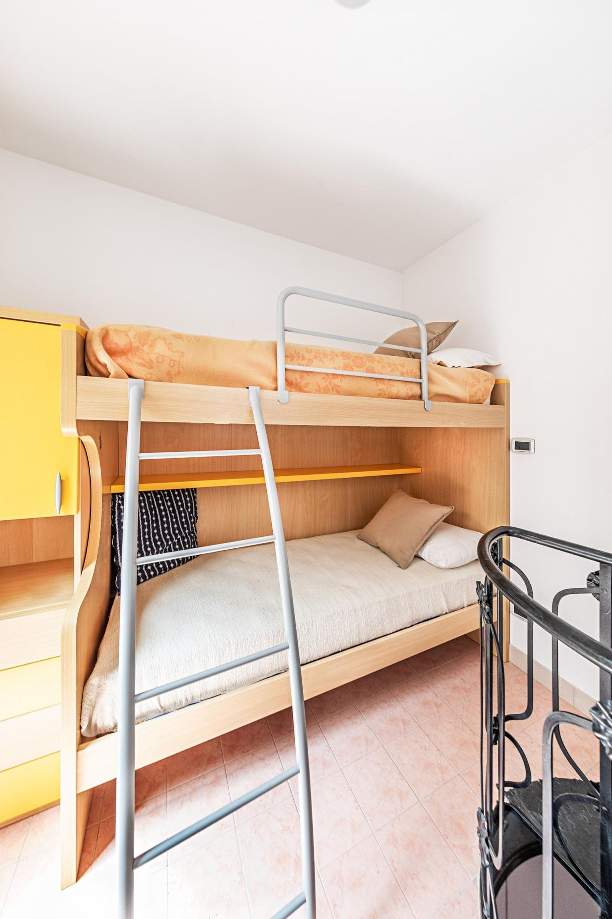 A bunk bed with a ladder, a small desk, and a chair.