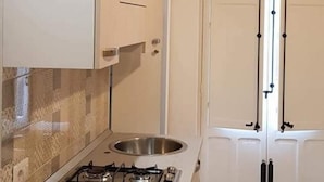 A kitchen with a gas stove, cabinets, and a tiled backsplash. - Casa White by Wonderful Italy (Cefalù)