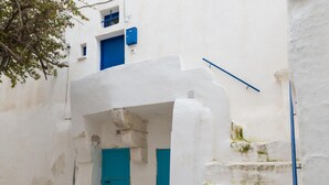 Um edifício branco com uma porta e escadaria azuis.