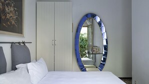 A bedroom with a bed, a wardrobe, a mirror, and a painting on the wall. - Una Terrazza su Rapallo by Wonderful Italy (Rapallo)